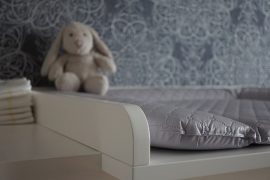 Chambre de bébé avec une table à langer et une peluche lapin