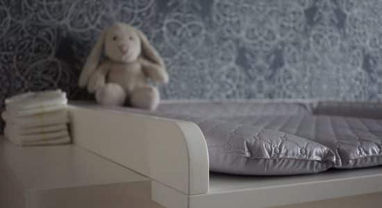 Chambre de bébé avec une table à langer et une peluche lapin